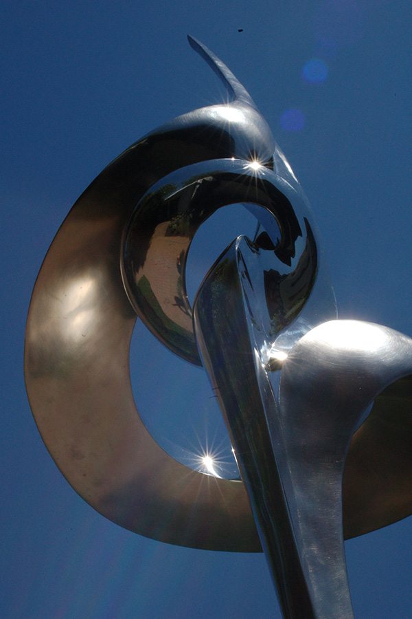 abstract stainless steel sculpture of swirls pointing towards the sky